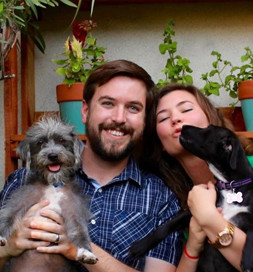 man and woman holding dogs